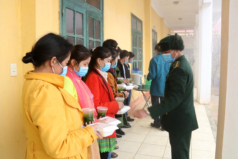 Đồn Biên phòng cửa khẩu Xín Mần, BĐBP Hà Giang phát cơm tới người dân trong thời gian làm thủ tục cách ly ở cửa khẩu. Ảnh: Kim Nhượng.